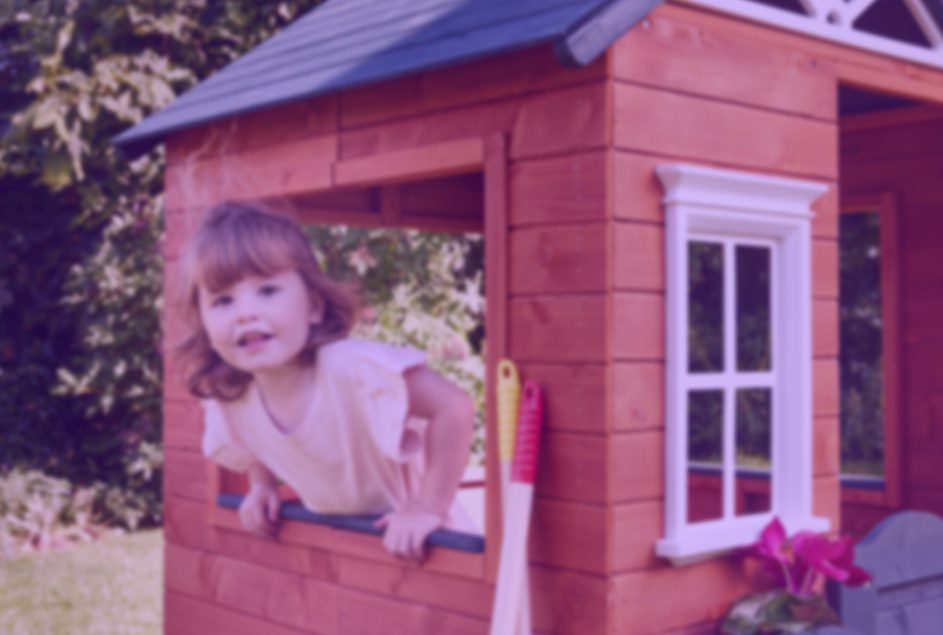 Young girl playing in a wooden playhouse