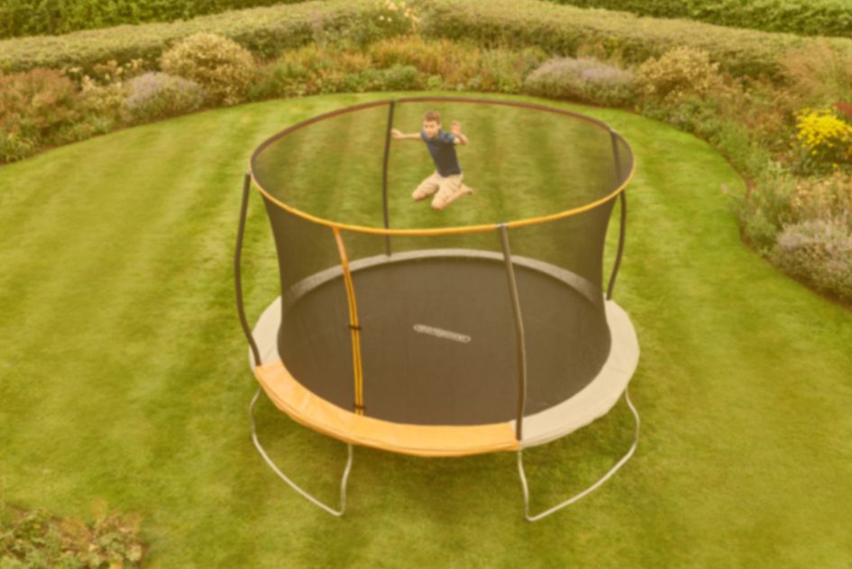 Young boy jumping on large trampoline